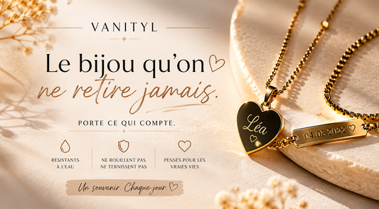 Visuel publicitaire Vanityl montrant deux colliers dorés personnalisés, un pendentif cœur gravé “Léa” et une plaque gravée “04.05.2022”, posés sur une pierre claire dans une ambiance douce et lumineuse. 